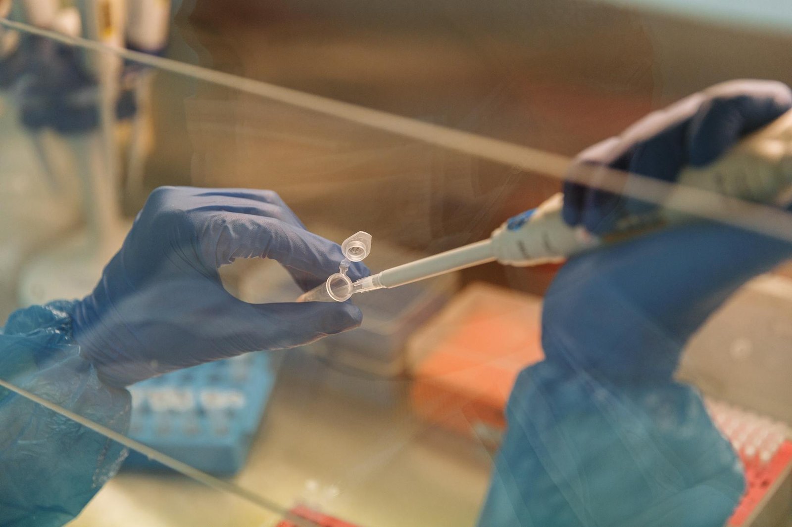 Close-up of scientist using a pipette with test tubes in a laboratory setting.